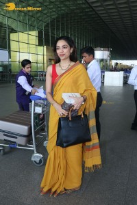 actress sobhita dhulipala wearing a yellow saree at mumbai airport
