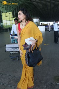 actress sobhita dhulipala wearing a yellow saree at mumbai airport