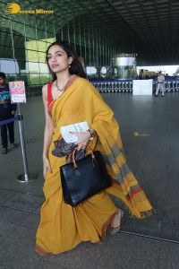 actress sobhita dhulipala wearing a yellow saree at mumbai airport