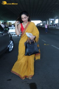 actress sobhita dhulipala wearing a yellow saree at mumbai airport