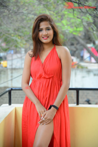 Telugu Heroine Sravani Nikki wearing a red dress and posing for photographs