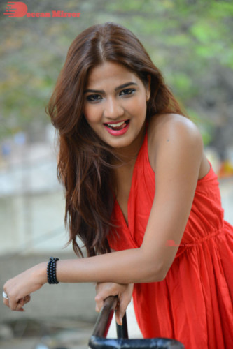 Telugu Heroine Sravani Nikki wearing a red dress and posing for photographs