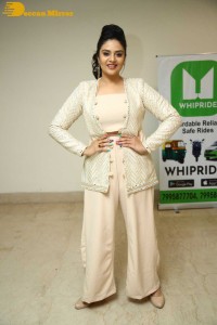 Sreemukhi posing for pictures in a white dress