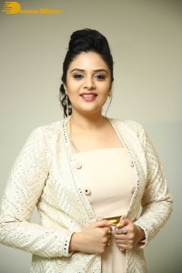 Sreemukhi posing for pictures in a white dress