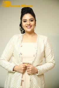 Sreemukhi posing for pictures in a white dress
