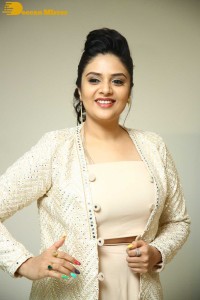 Sreemukhi posing for pictures in a white dress