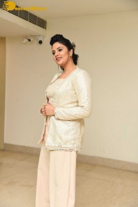 Sreemukhi posing for pictures in a white dress