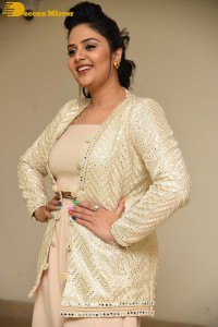 Sreemukhi posing for pictures in a white dress
