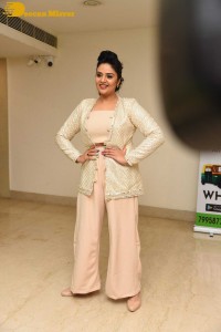 Sreemukhi posing for pictures in a white dress