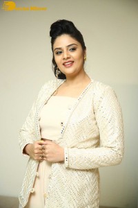 Sreemukhi posing for pictures in a white dress