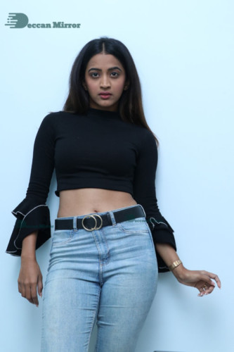Actress Sruthi Shetty in a black top and blue jeans