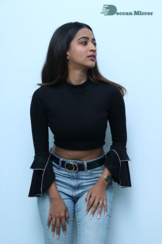 Actress Sruthi Shetty in a black top and blue jeans