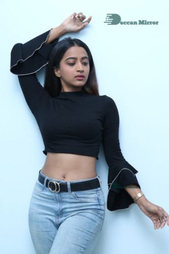 Actress Sruthi Shetty in a black top and blue jeans