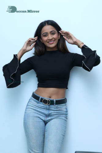 Actress Sruthi Shetty in a black top and blue jeans