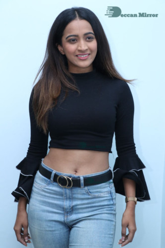 Actress Sruthi Shetty in a black top and blue jeans