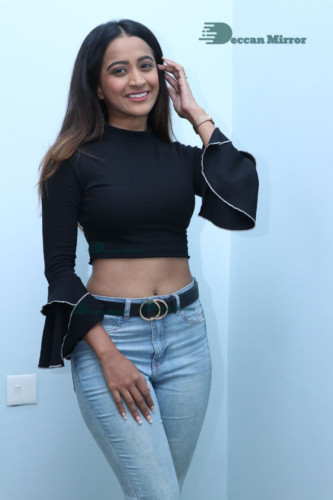 Actress Sruthi Shetty in a black top and blue jeans