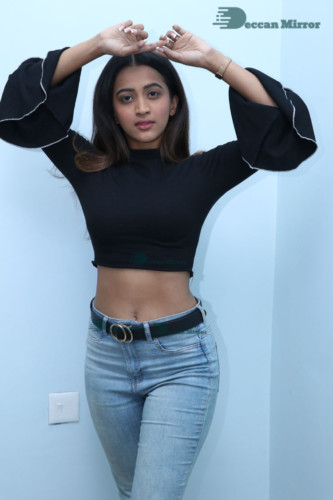 Actress Sruthi Shetty in a black top and blue jeans