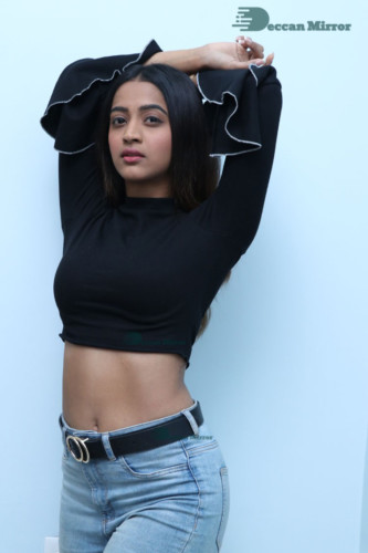 Actress Sruthi Shetty in a black top and blue jeans