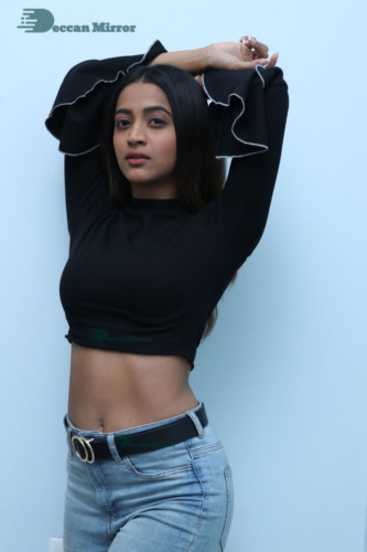 Actress Sruthi Shetty in a black top and blue jeans