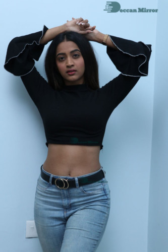 Actress Sruthi Shetty in a black top and blue jeans