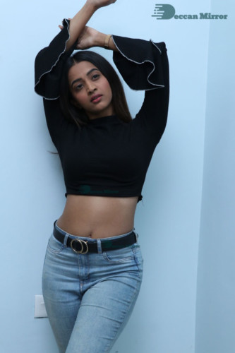 Actress Sruthi Shetty in a black top and blue jeans