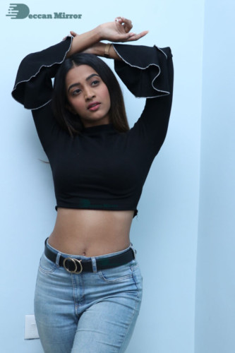 Actress Sruthi Shetty in a black top and blue jeans