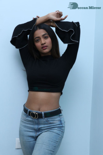 Actress Sruthi Shetty in a black top and blue jeans