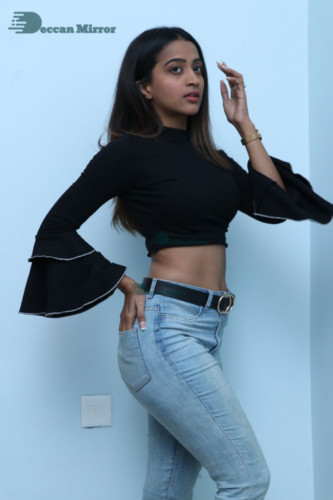 Actress Sruthi Shetty in a black top and blue jeans