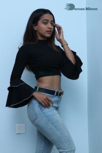 Actress Sruthi Shetty in a black top and blue jeans