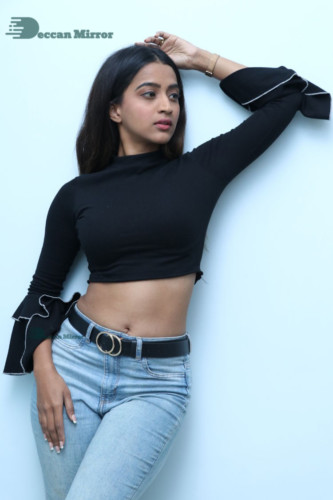 Actress Sruthi Shetty in a black top and blue jeans
