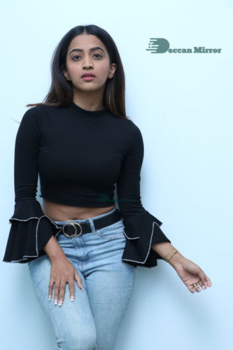 Actress Sruthi Shetty in a black top and blue jeans