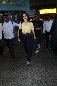 indian actress sunny leone in a yellow shirt and black jeans