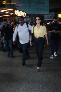 indian actress sunny leone in a yellow shirt and black jeans