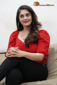 Tamil and Telugu Actress Surbhi Puranik in a red top and black jeans
