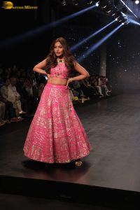 Indian actress Surbhi Chandna gorgeous in a pink lehenga choli doing a ramp walk