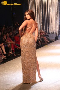 Tara Sutaria wearing a gold color dress for her ramp walk at Bombay Times Fashion Week