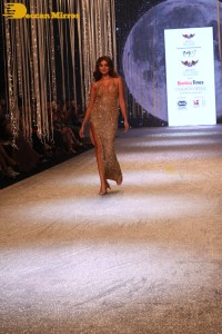 Tara Sutaria wearing a gold color dress for her ramp walk at Bombay Times Fashion Week