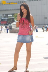 Trisha in a pink top and denim mini skirt on location for a film shoot