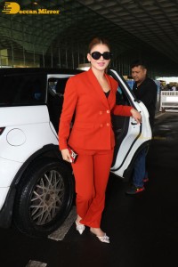 Urvashi Rautela in a red pant suit at the Mumbai Airport