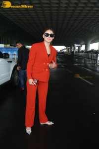 Urvashi Rautela in a red pant suit at the Mumbai Airport