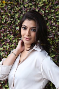 Varalaxmi Sarathkumar sexy looks in a white shirt and red skirt