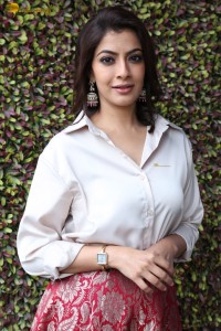 Varalaxmi Sarathkumar sexy looks in a white shirt and red skirt