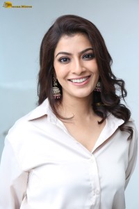 Varalaxmi Sarathkumar sexy looks in a white shirt and red skirt